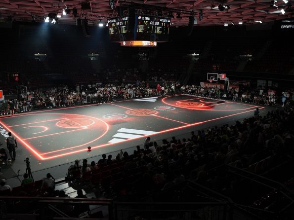 An LED-lit basketball court with Adidas branding and a full house at BMW Park Munich.
