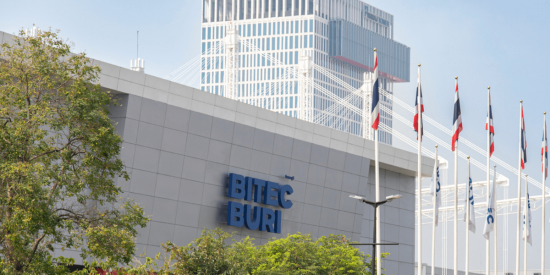 Fassade des BITEC BURI in Bangkok mit Flaggen und Hochhaus im Hintergrund