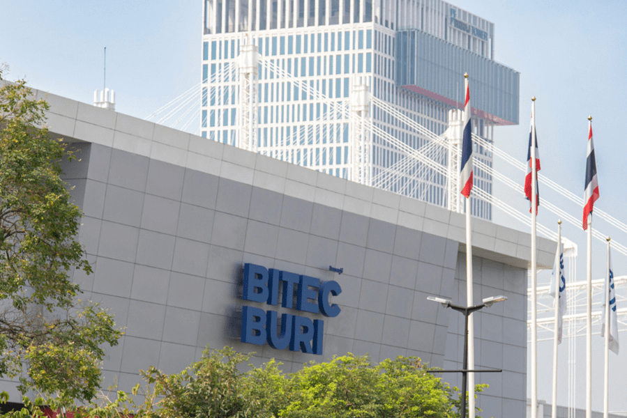 Fassade des BITEC BURI in Bangkok mit Flaggen und Hochhaus im Hintergrund
