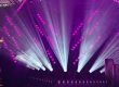 Violet and white beams of light create a stage filled with dynamic effects.