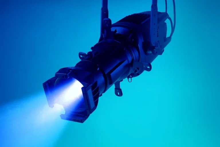 elation-kl-core-ip Ein schwarzer LED-Scheinwerfer strahlt einen intensiven blauen Lichtkegel aus.