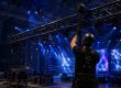 Technicians setting up a stage truss with lighting equipment and blue show lighting