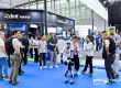 A robot is observed by trade visitors at the Prolight + Sound Guangzhou exhibition stand.
