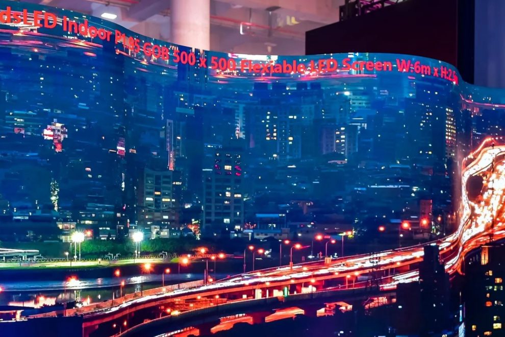 Curved LED wall shows nocturnal city view on a trade fair stand
