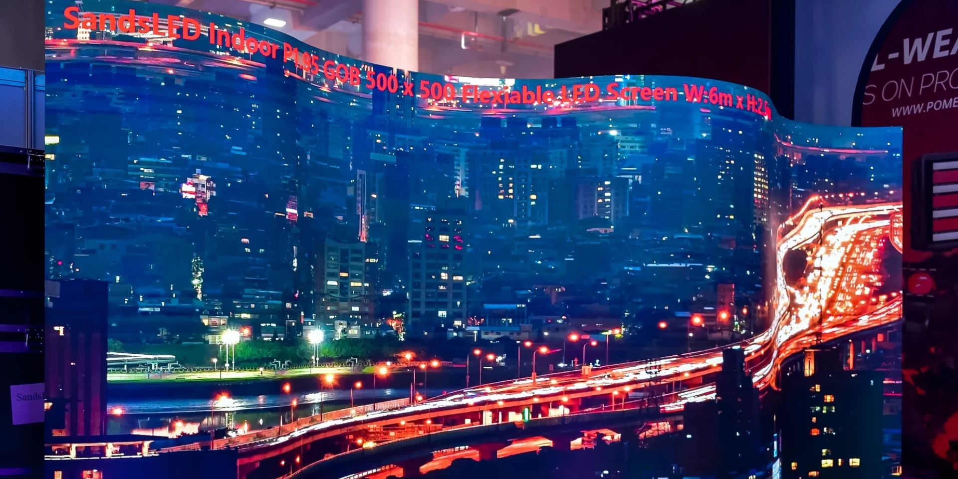 Curved LED wall shows nocturnal city view on a trade fair stand