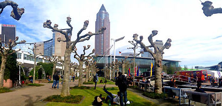 People on the outdoor area of Messe Frankfurt with the exhibition tower and bare trees.