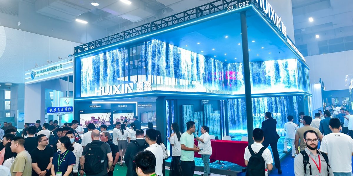 Exhibition stand with large LED installation, many visitors talking and exploring