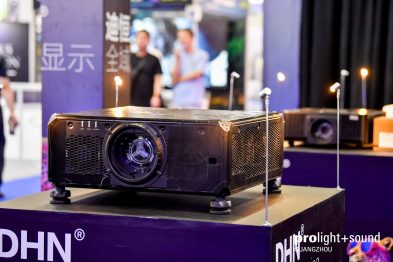 Projektoren auf Messestand mit unscharfen Besuchern im Hintergrund